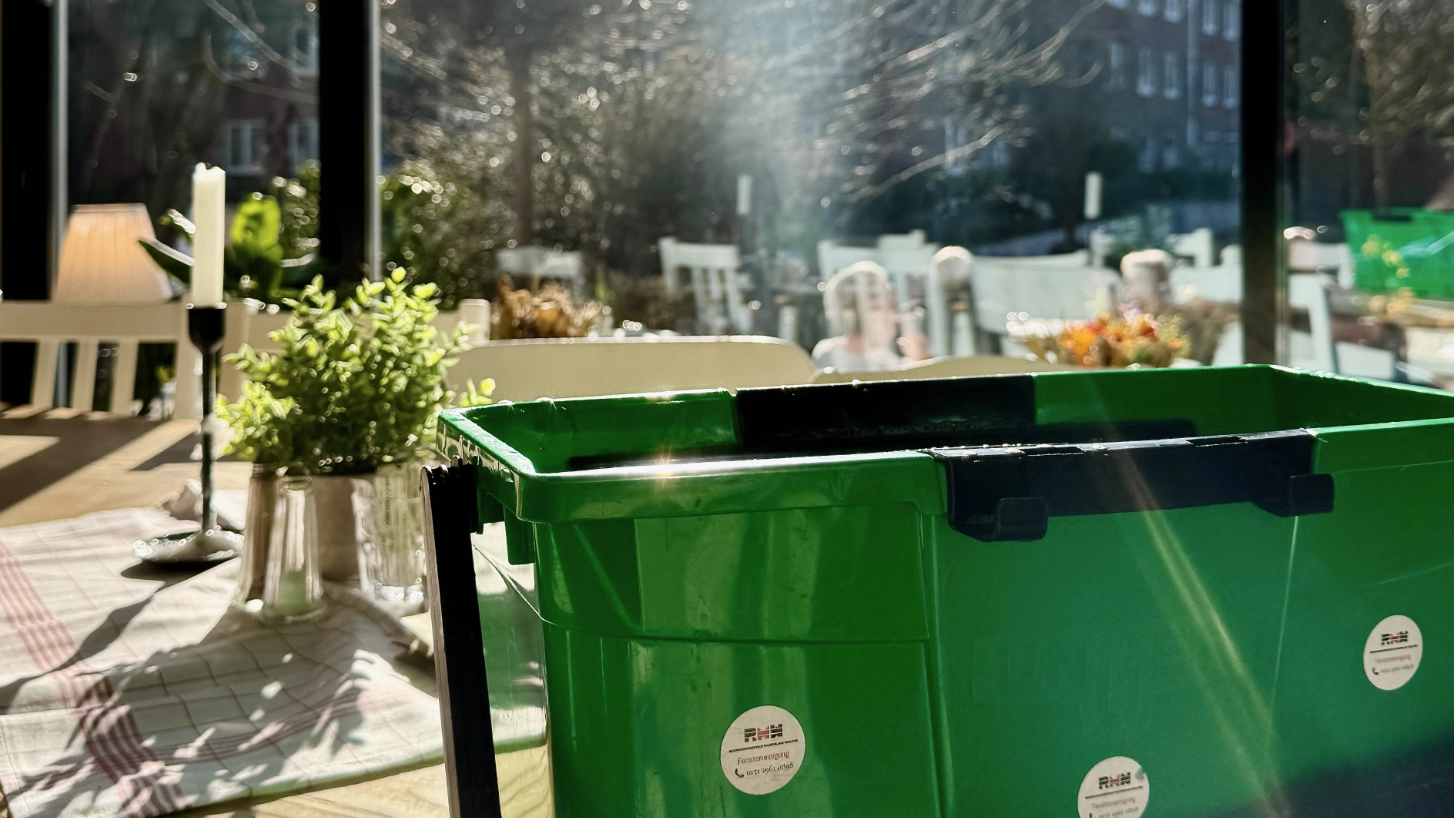 Arbeitsmaterial für die Fensterreinigung vor einer sonnigen Fensterfront